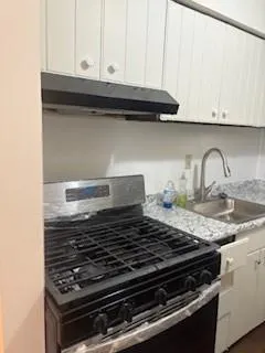 a stove top oven sitting inside of a kitchen