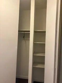 a view of walk in closet with empty racks