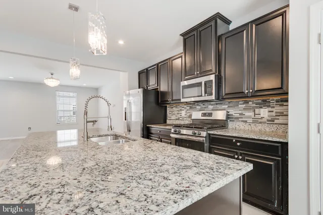 a kitchen with stainless steel appliances granite countertop a stove refrigerator and cabinets