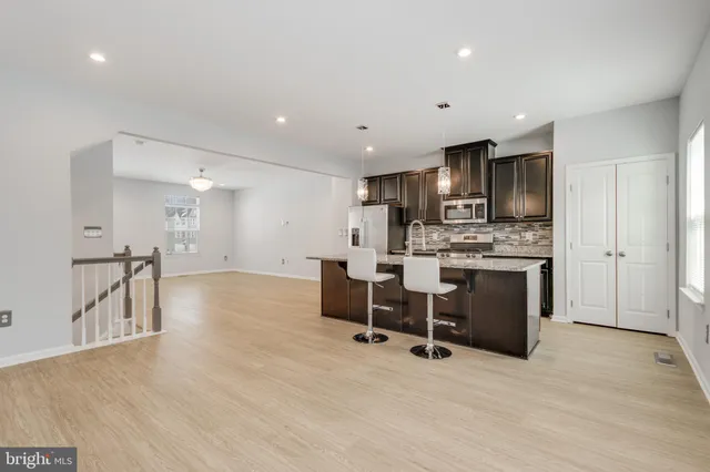 an empty room with furniture and view of kitchen