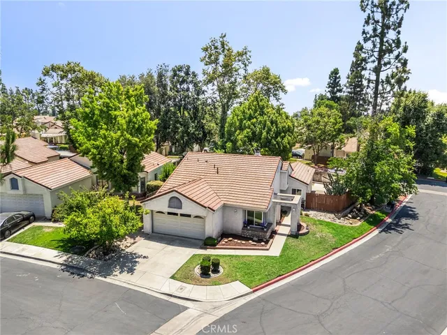 an aerial view of a house with a yard and potted plants