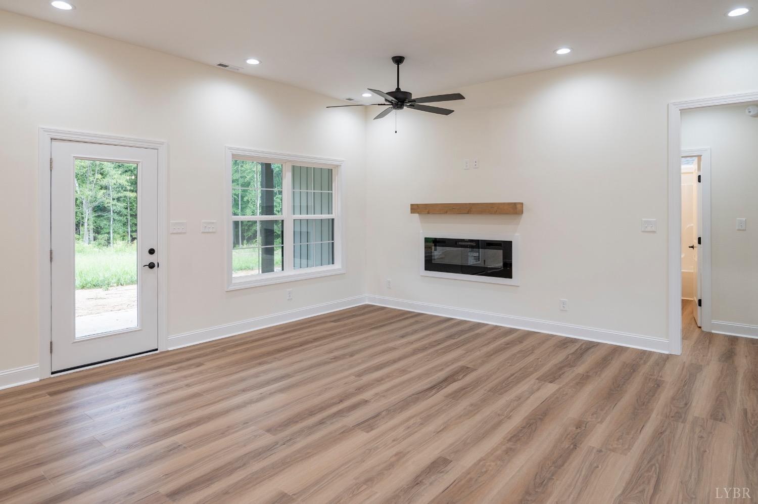 1738 Willow Oak Drive Forest, VA 24551 - Photo 13 of 54 a view of an empty room with wooden floor fireplace and a window