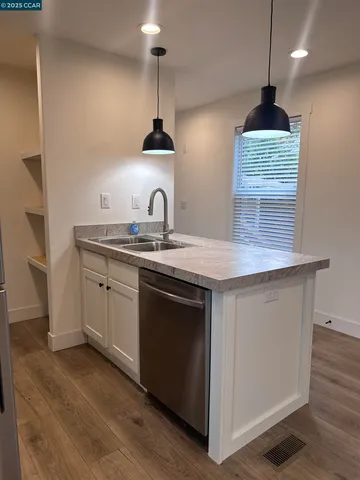 a kitchen with stainless steel appliances a sink stove and cabinets