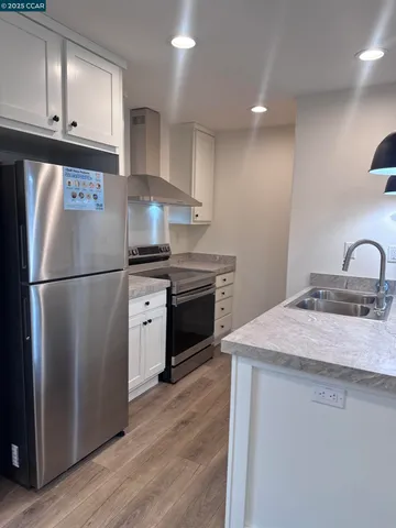a kitchen with a sink a refrigerator and cabinets