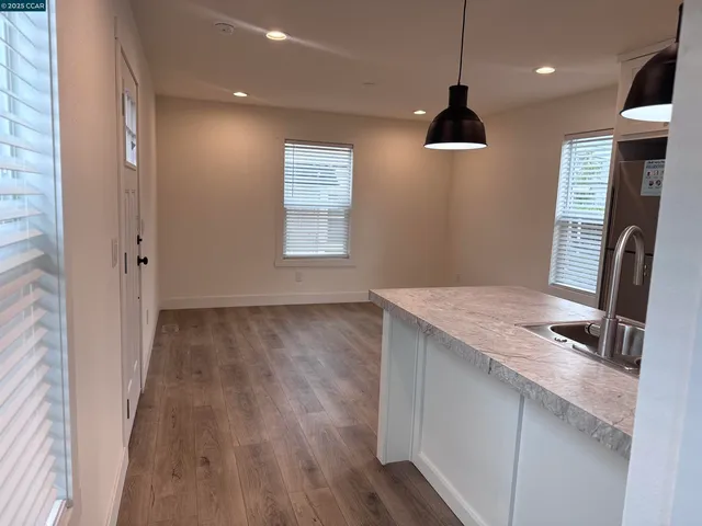 a view of a kitchen cabinets a sink a window and wooden floor