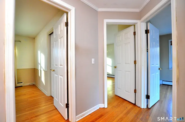 a view of a hallway with wooden floor and closet