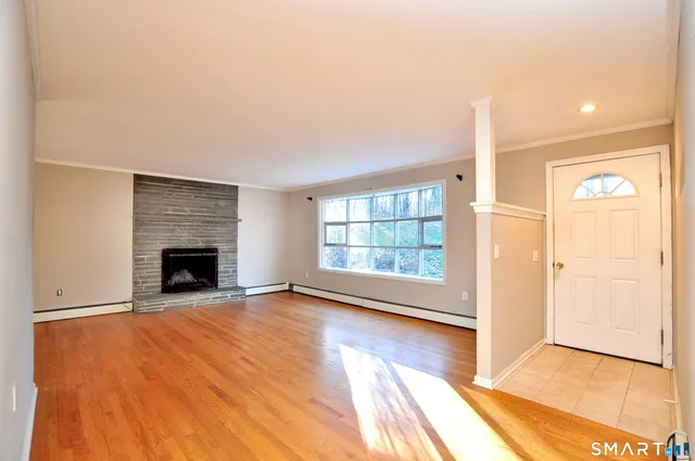 a view of an empty room with a window and fireplace