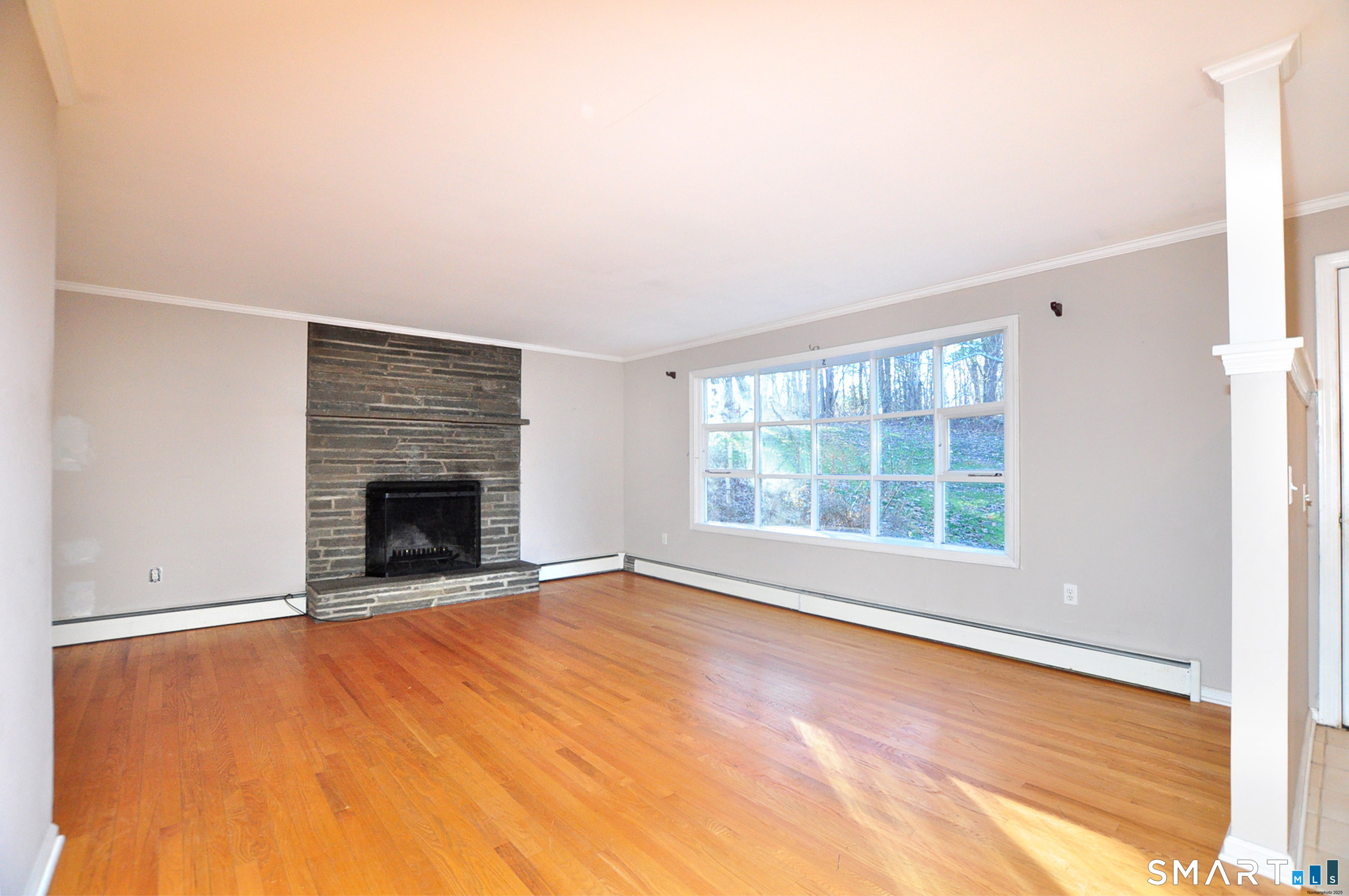 204 Goodhouse Road Litchfield, CT 06759 - Photo 10 of 37 an empty room with floor to ceiling window and fireplace