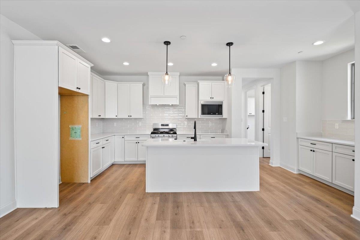 467 Armel Drive Collierville, TN 38017 - Photo 7 of 37 a large kitchen with cabinets wooden floor and stainless steel appliances
