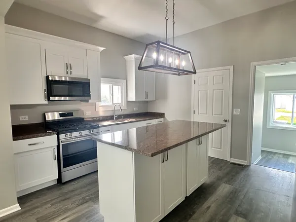 a kitchen with stainless steel appliances granite countertop a sink and stove top oven