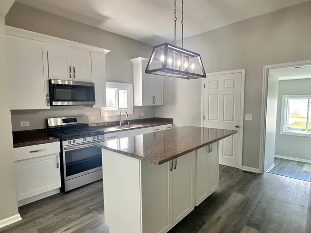 a kitchen with stainless steel appliances granite countertop a sink and stove top oven