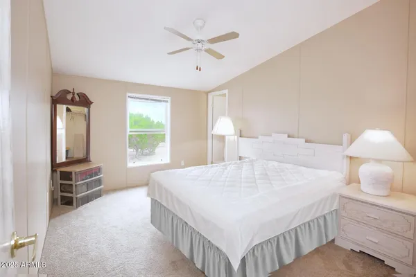a bedroom with a bed a window and dresser