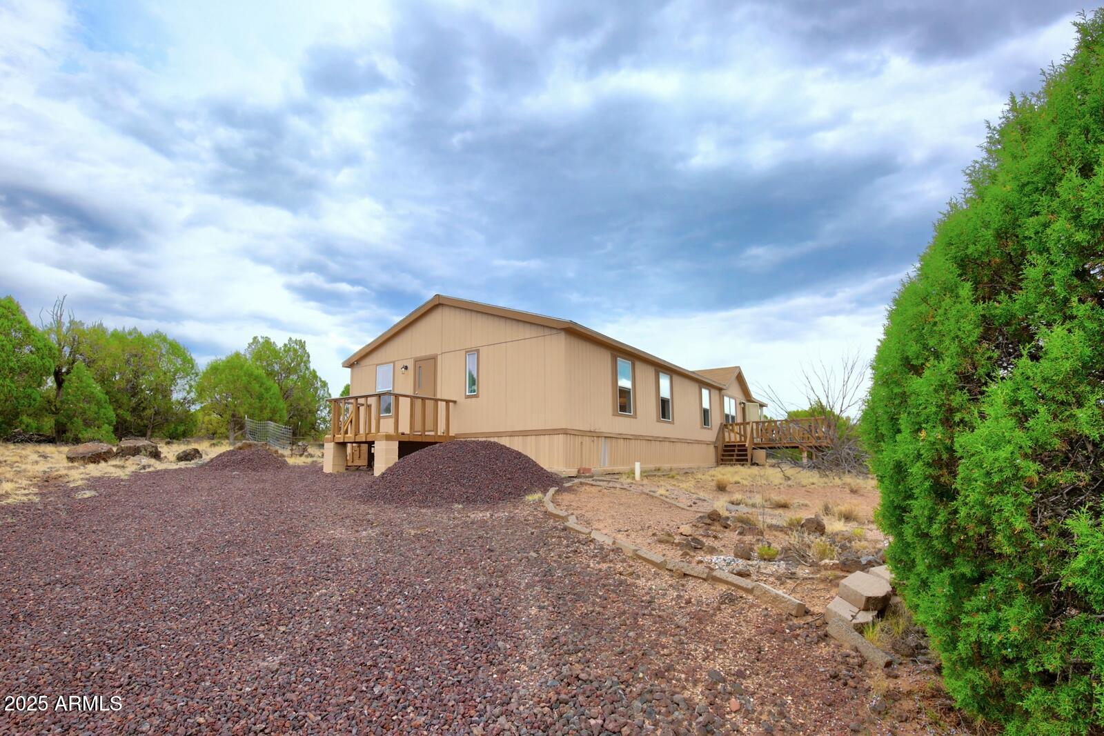 7865 Christmas Tree Road Show Low, AZ 85901 - Photo 2 of 32 a view of a house with a dry yard and large trees