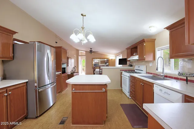 a kitchen with stainless steel appliances granite countertop a sink stove and refrigerator