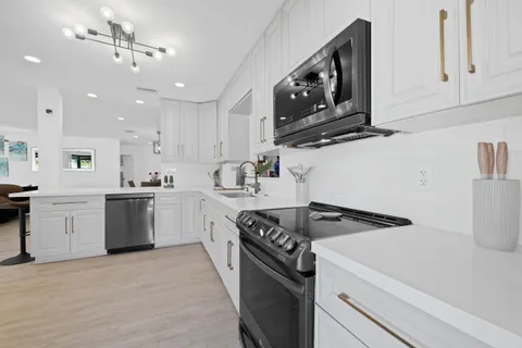 a kitchen with white cabinets and window