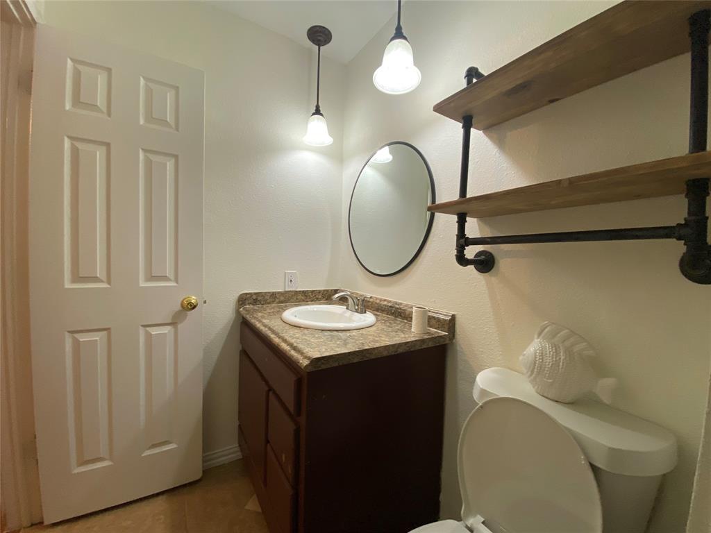 2018 Clark Trail Grand Prairie, TX 75052 - Photo 30 of 40 a bathroom with a sink a toilet and a mirror