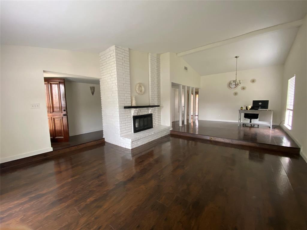2018 Clark Trail Grand Prairie, TX 75052 - Photo 5 of 40 an empty room with wooden floor fireplace and windows