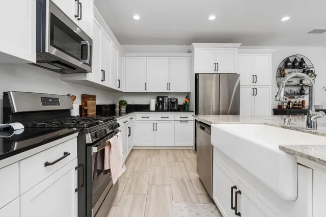 a kitchen with stainless steel appliances a stove sink microwave and cabinets