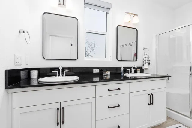 a bathroom with double vanity sinks and a mirror