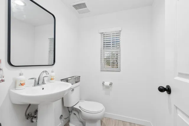 a bathroom with a toilet a sink and mirror