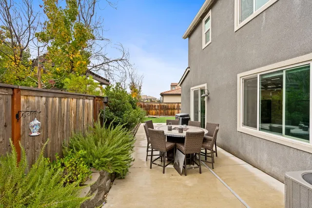 a view of a dinning table and chairs in patio of the house