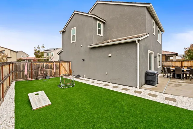 a backyard of a house with table and chairs