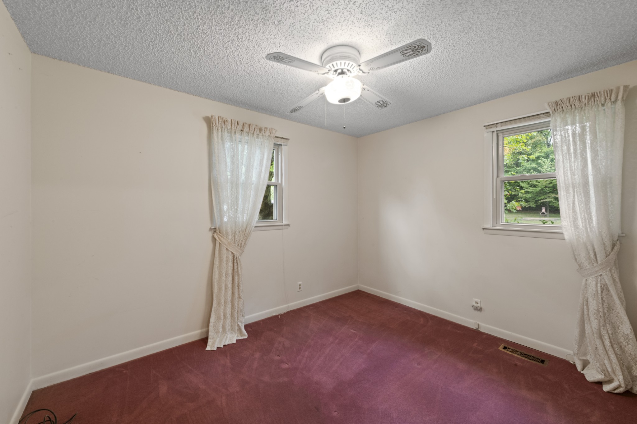 357 Raymond Hodges Road Cottontown, TN 37048 - Photo 14 of 21 an empty room with a chandelier fan and windows