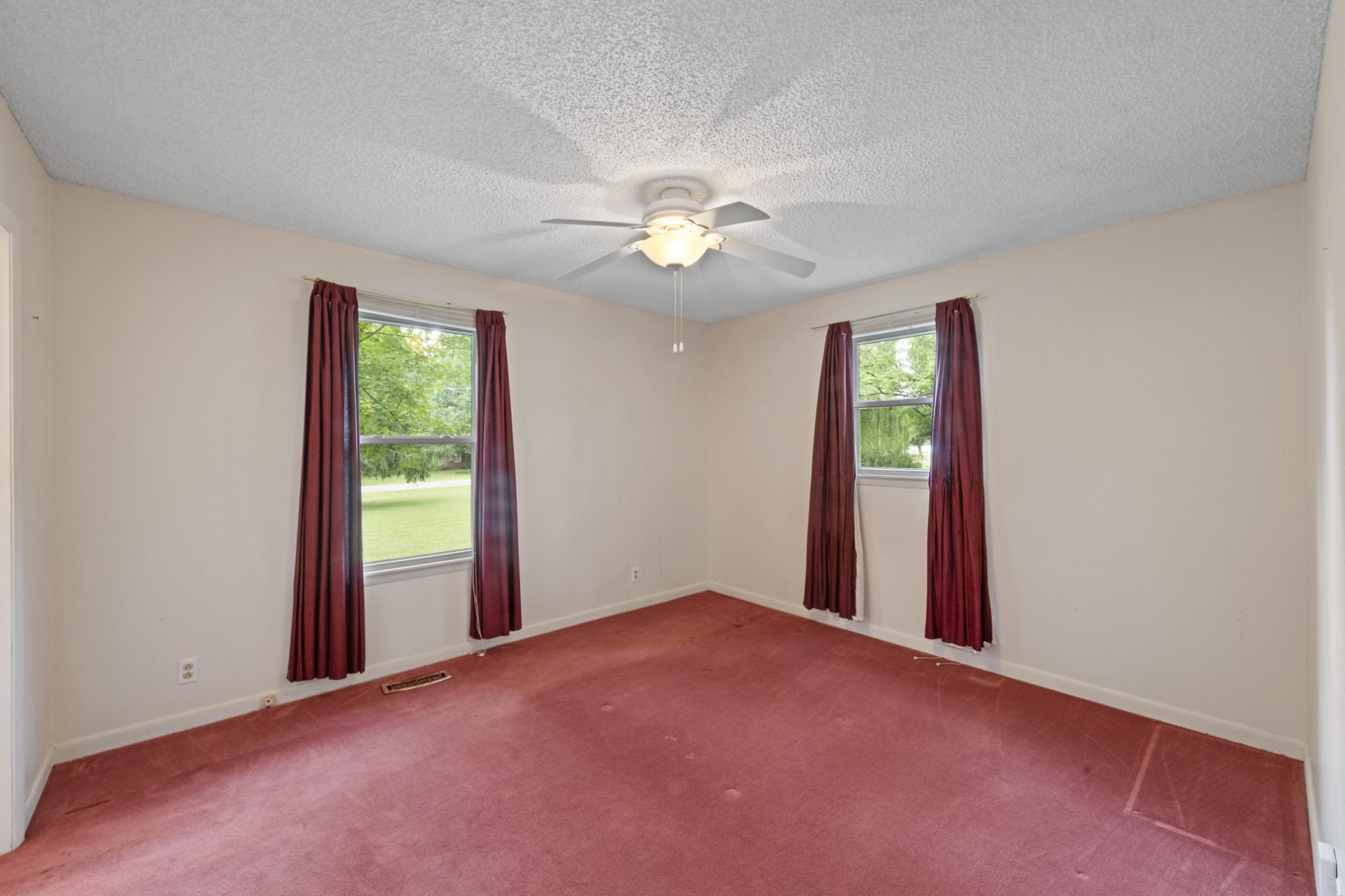 357 Raymond Hodges Road Cottontown, TN 37048 - Photo 10 of 21 an empty room with windows and a chandelier fan