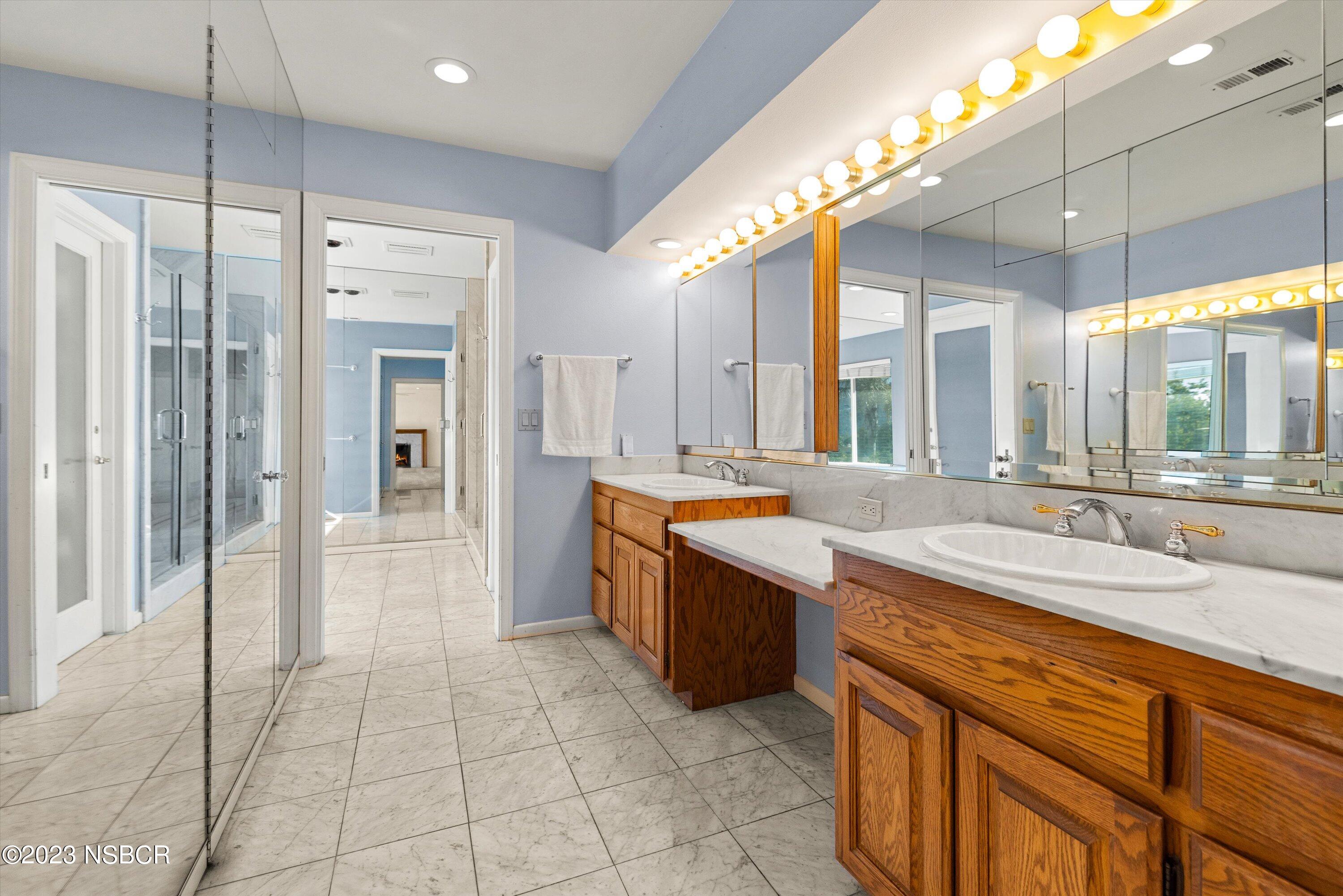 345 Meadowlark Road Santa Ynez, CA 93460 - Photo 24 of 57 a large bathroom with a large mirror vanity and shower