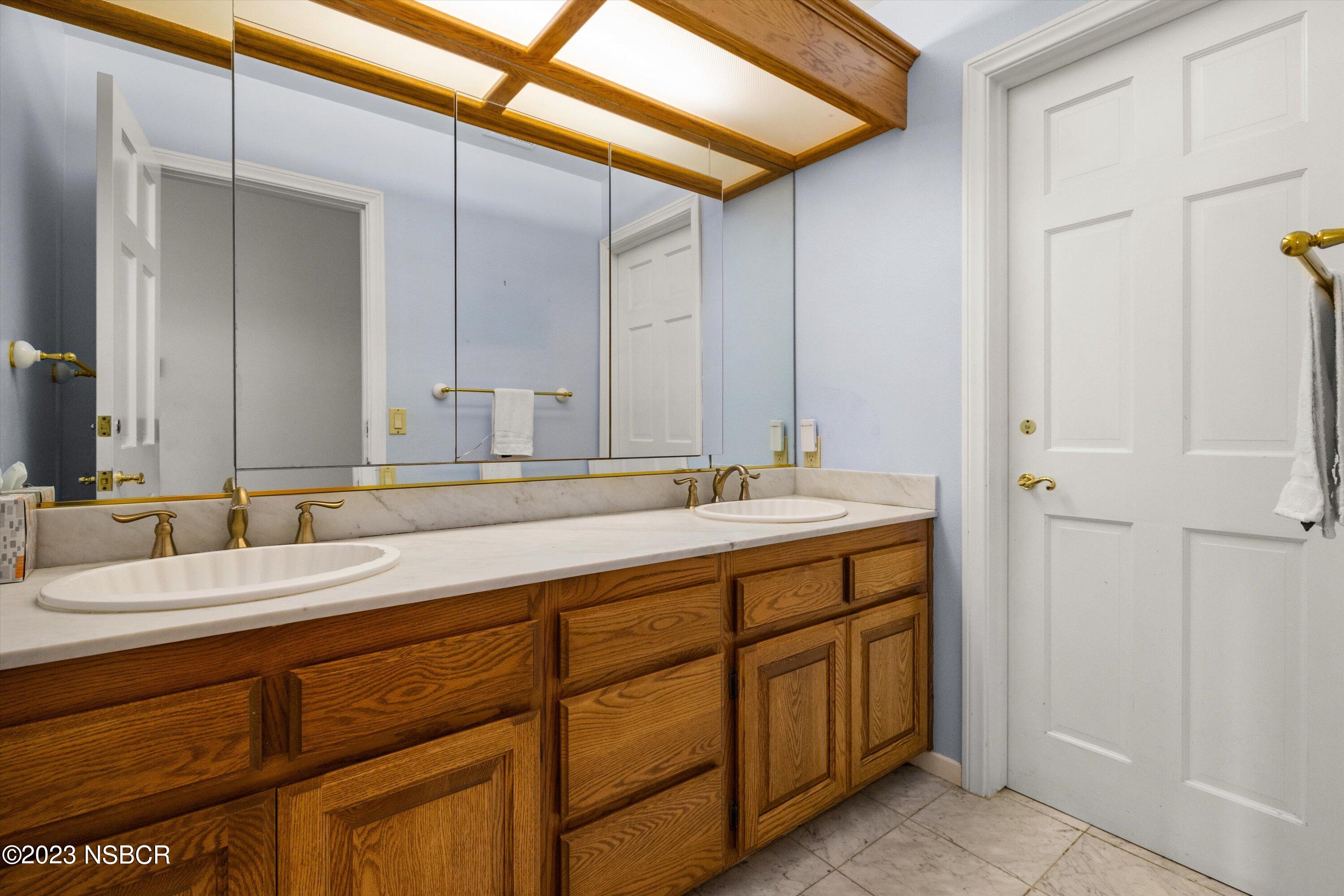 345 Meadowlark Road Santa Ynez, CA 93460 - Photo 29 of 57 a bathroom with a double vanity sink and a mirror
