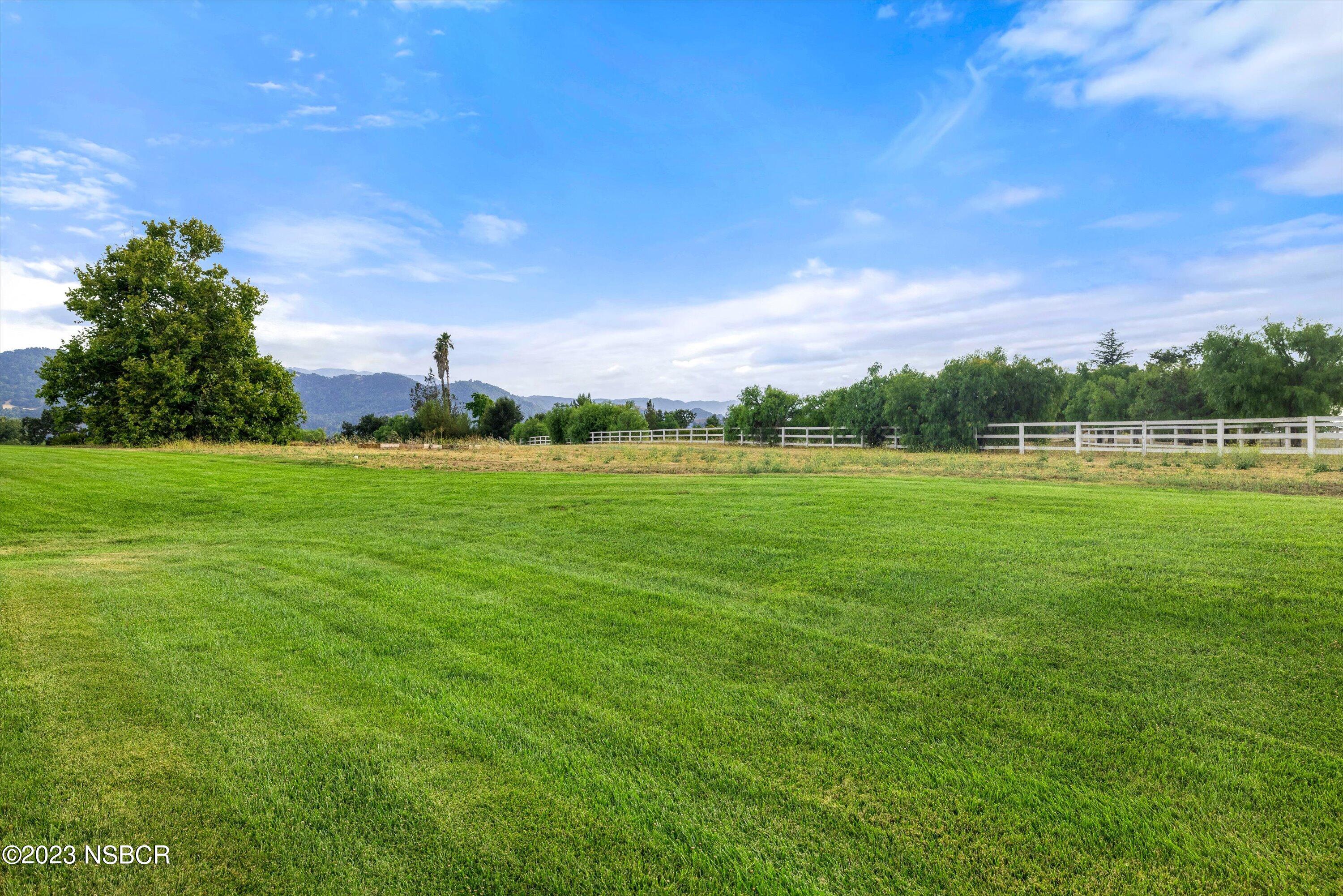 345 Meadowlark Road Santa Ynez, CA 93460 - Photo 45 of 57 a backyard of a house with lots of green space and mountain view in back