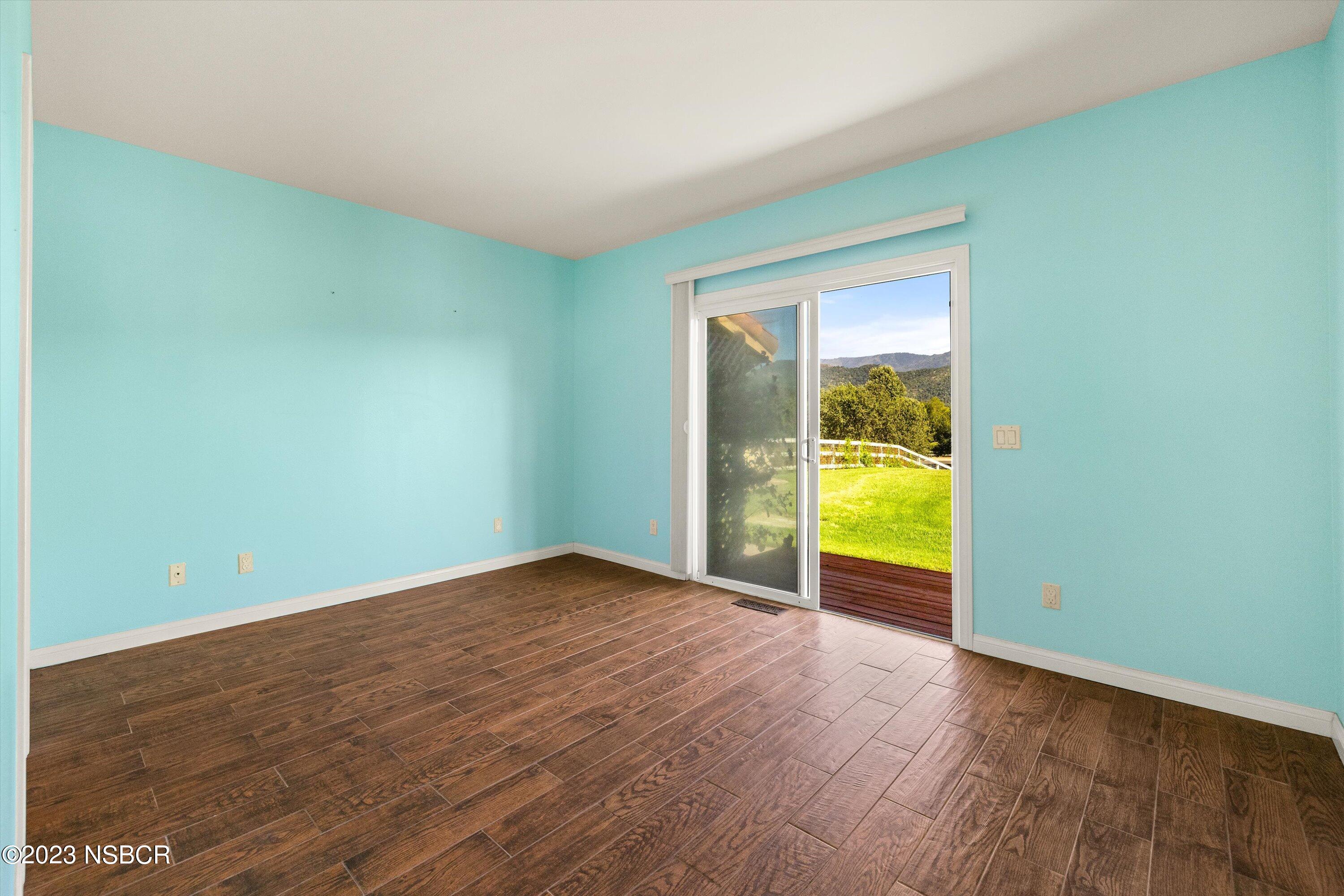 345 Meadowlark Road Santa Ynez, CA 93460 - Photo 8 of 57 an empty room with wooden floor and sliding door