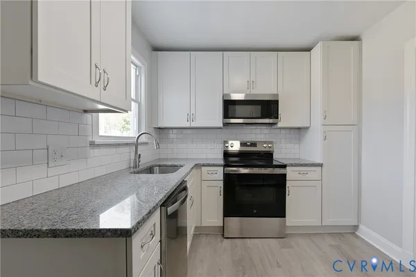 a view of a refrigerator in kitchen and white cabinets