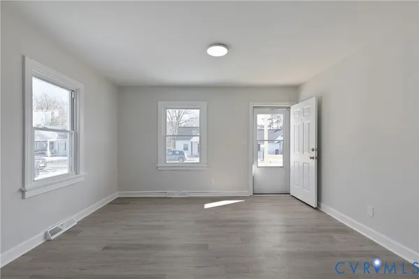 an empty room with windows and closet