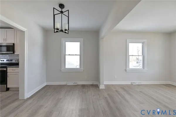 a kitchen with stainless steel appliances granite countertop white cabinets sink and a microwave