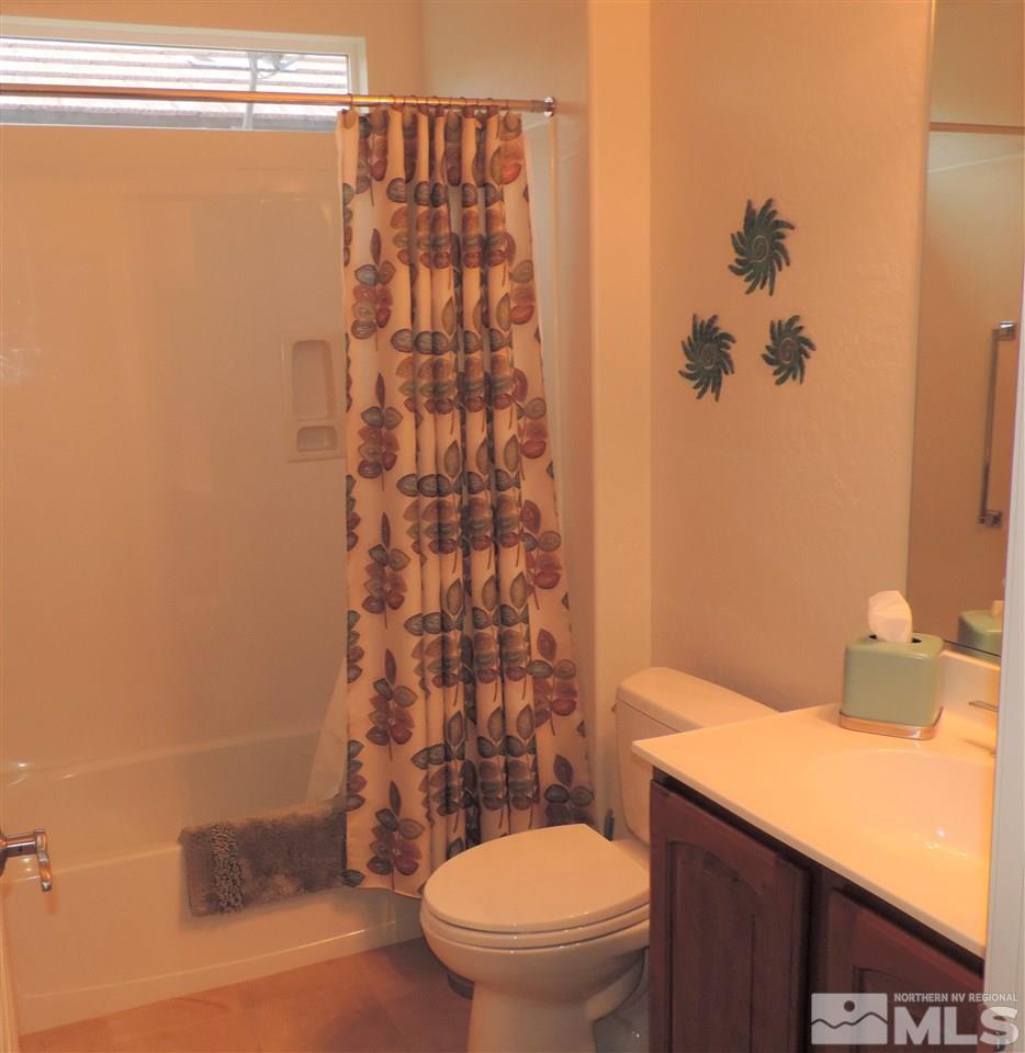 9142 Mount Pleasant Drive Reno, NV 89523 - Photo 13 of 34 a bathroom with a toilet a sink and curtain