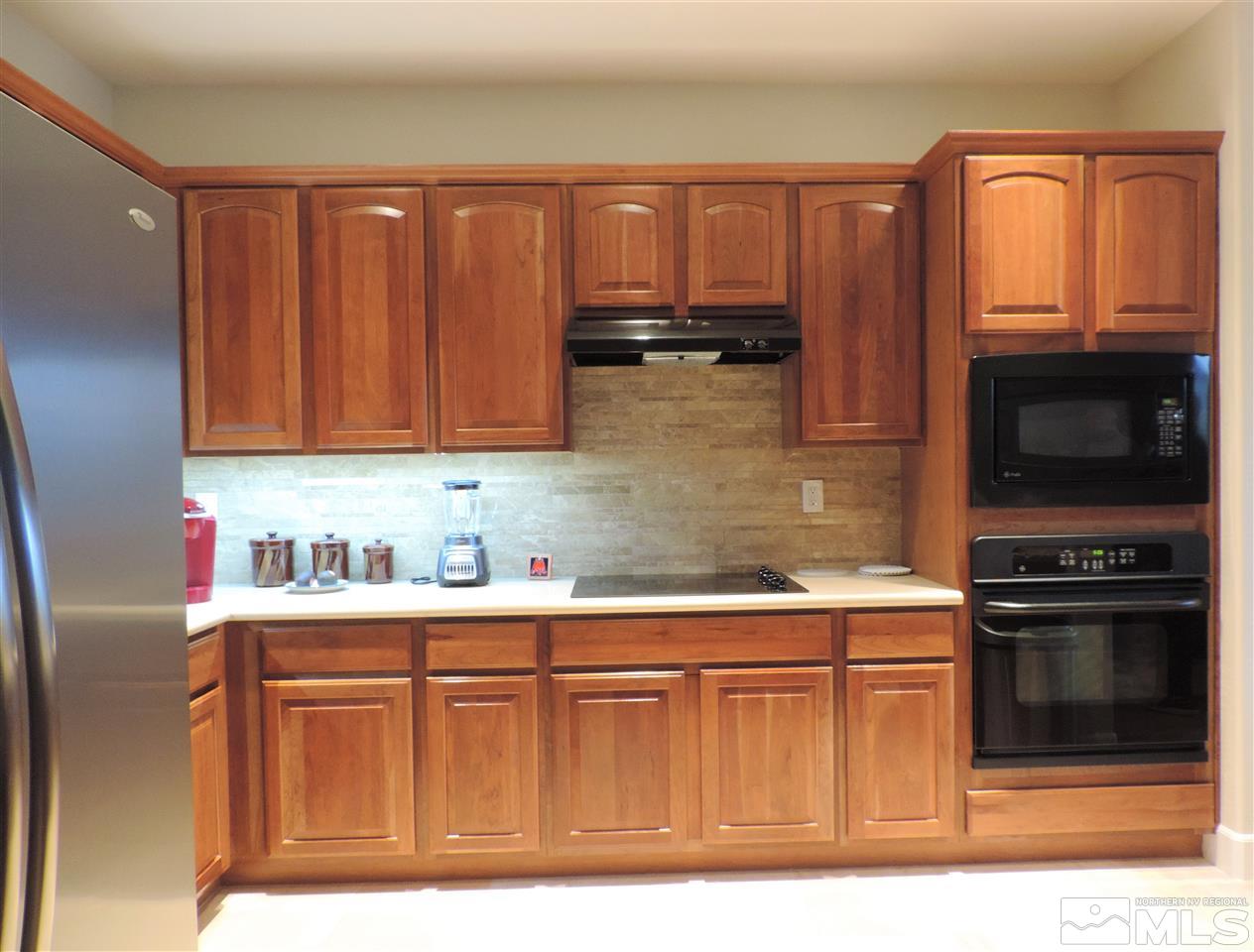 9142 Mount Pleasant Drive Reno, NV 89523 - Photo 6 of 34 a kitchen with granite countertop a stove top oven microwave and cabinets