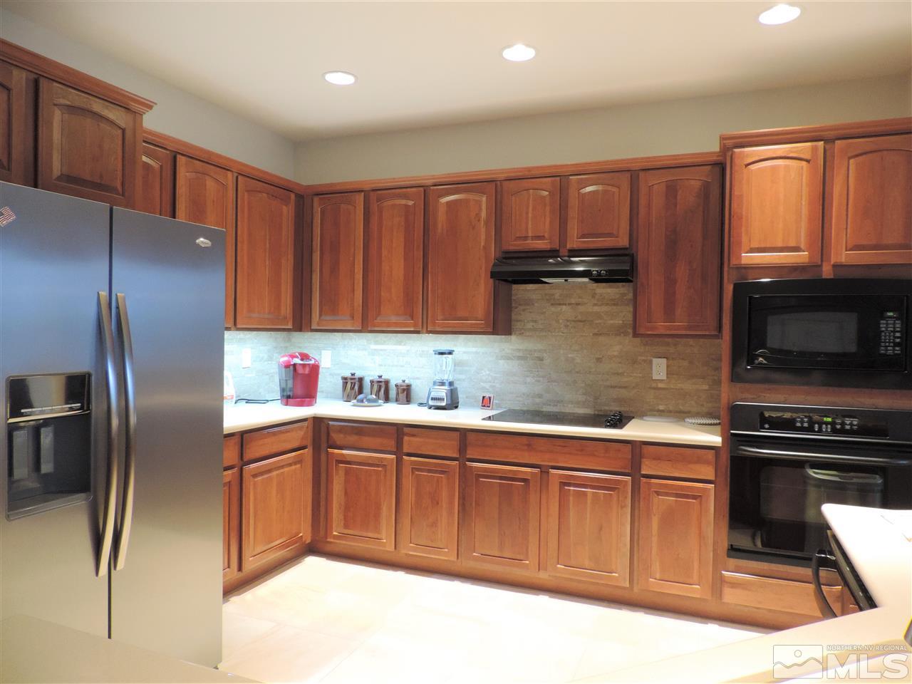 9142 Mount Pleasant Drive Reno, NV 89523 - Photo 7 of 34 a kitchen with stainless steel appliances granite countertop a refrigerator and a stove top oven