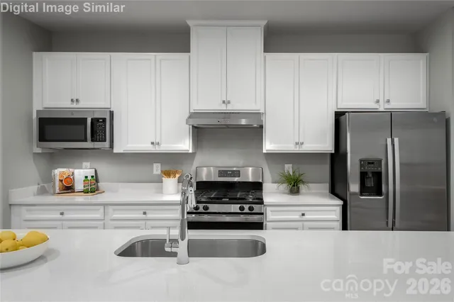 a kitchen with stainless steel appliances granite countertop a refrigerator sink and stove