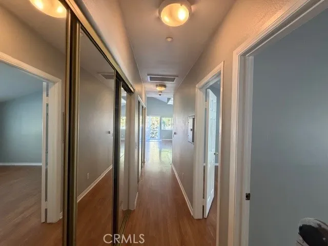 a view of a hallway with wooden floor and staircase