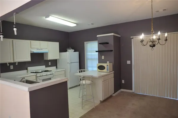 a kitchen that has a lot of cabinets in it and wooden cabinets