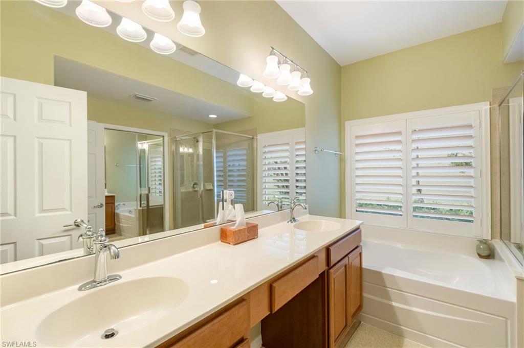 5857 Constitution Street Ave Maria, FL 34142 - Photo 14 of 40 a bathroom with a tub sink and mirror