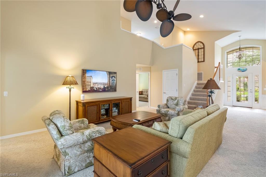 5857 Constitution Street Ave Maria, FL 34142 - Photo 6 of 40 a living room with furniture a fireplace and a large window