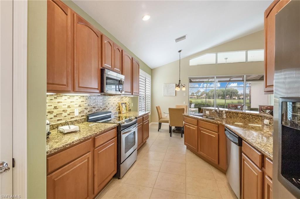 5857 Constitution Street Ave Maria, FL 34142 - Photo 8 of 40 a large kitchen with stainless steel appliances granite countertop a stove a sink and a refrigerator