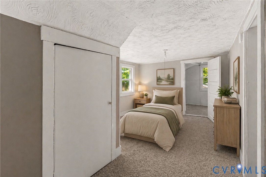 2097 Coles Point Road Hague, VA 22469 - Photo 13 of 34 a spacious bedroom with a bed and a chandelier