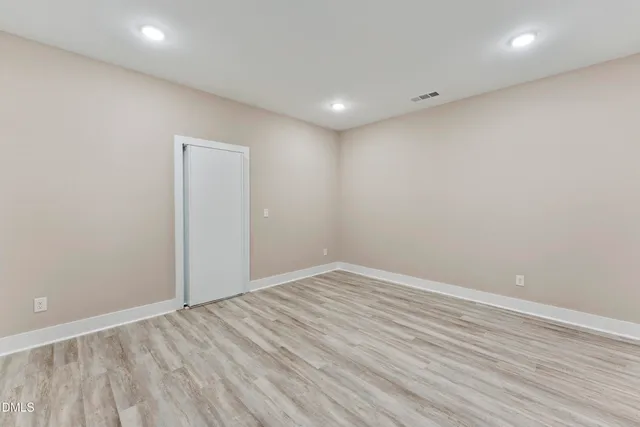 a view of empty room with wooden floor