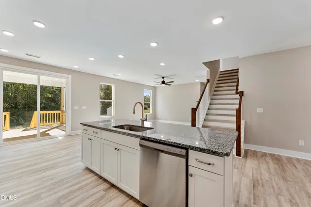 a kitchen with granite countertop kitchen island a sink and a large window