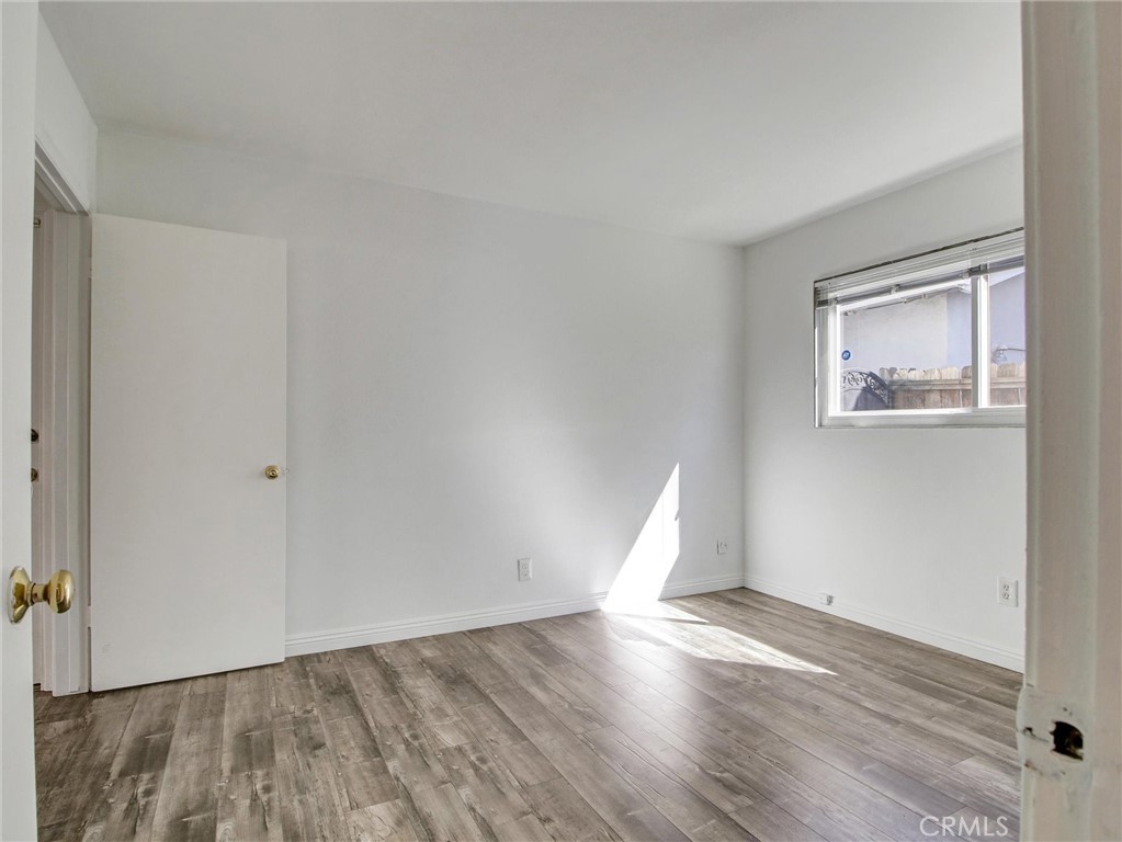 17815 Lysander Drive Carson, CA 90746 - Photo 19 of 24 an empty room with wooden floor and windows