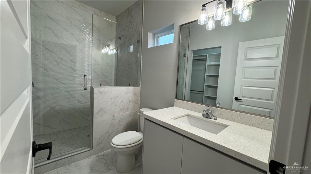 906 Hidden Hills St Mission, Unit 3 Mission, TX 78572 - Photo 8 of 10 Bathroom with toilet, walk in shower, vanity with extensive cabinet space, and tile flooring