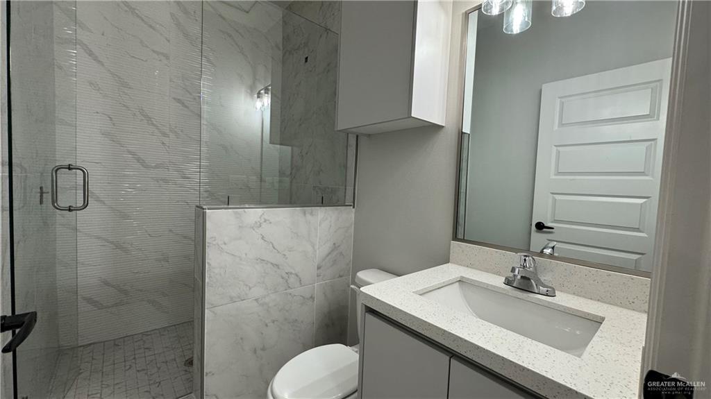 906 Hidden Hills St Mission, Unit 3 Mission, TX 78572 - Photo 10 of 10 Bathroom featuring an enclosed shower, vanity, and toilet